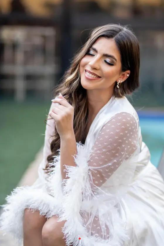 Noiva de robe, sorrindo, na preparação