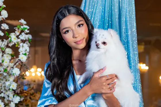 Debutante de robe azul abraçada ao cachorrinho branco