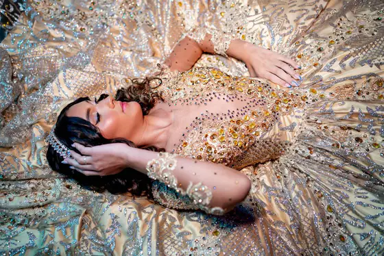 Debutante deitada sobre o vestido dourado, vista de cima