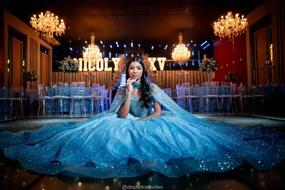 Debutante de vestido azul claro sentada no salão decorado